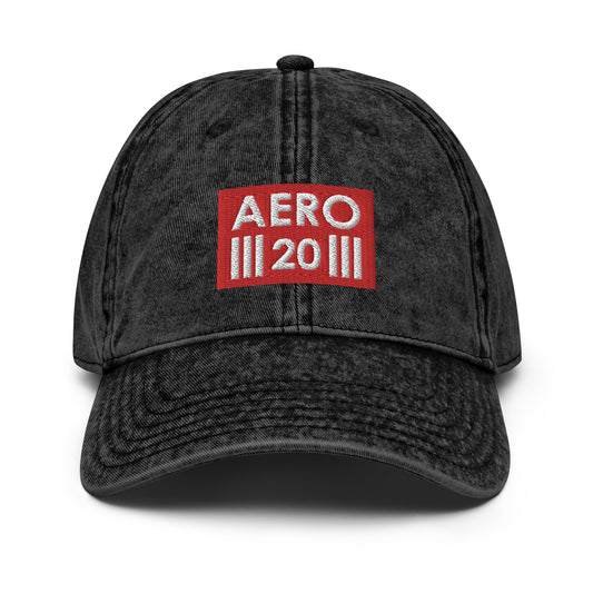 The picture shows the front of a black washed effect baseball cap with the red and white Aero Two Zero logo.