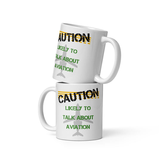 Ceramic white glossy mug with "Caution Likely to Talk About Aviation" over a grey silhouette of a jet on the front and back.