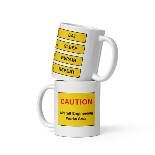 The aircraft engineer's ceramic white mug with "Eat, Sleep, Repair, Repeat" wording along with airport icon signage in black and yellow on the back and with "Caution Aircraft Engineering Works Area" on the front.